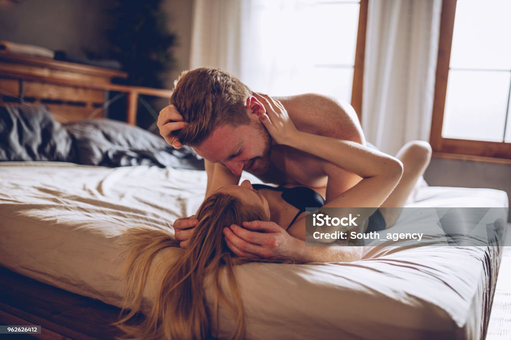 Desire Couple cuddling in the bedroom Sexual Issues Stock Photo