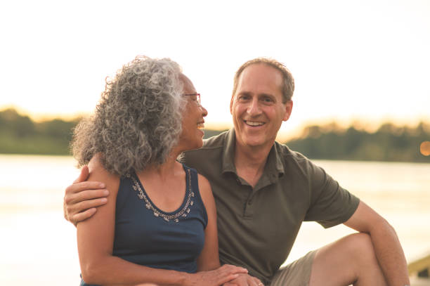 istock Interracial senior couple sit on the dock on a summer evening 962631932