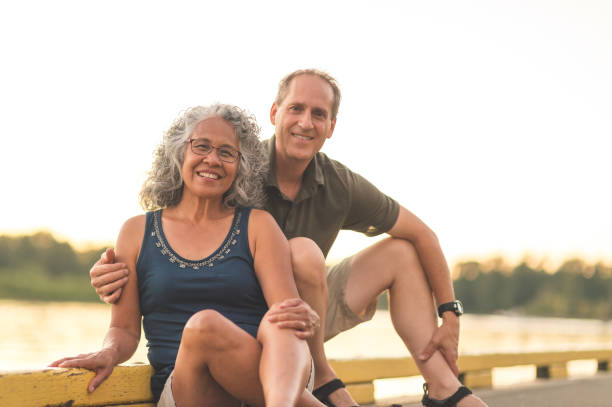 istock Interracial senior couple sit on the dock on a summer evening 962631974