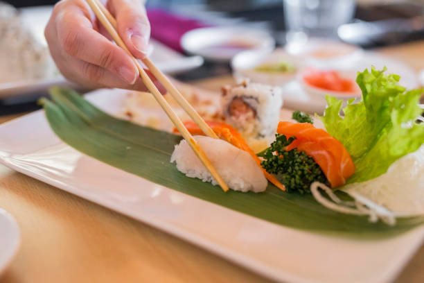 istock closeup of hands taking sushi with chinese chopsticks 2 962638004