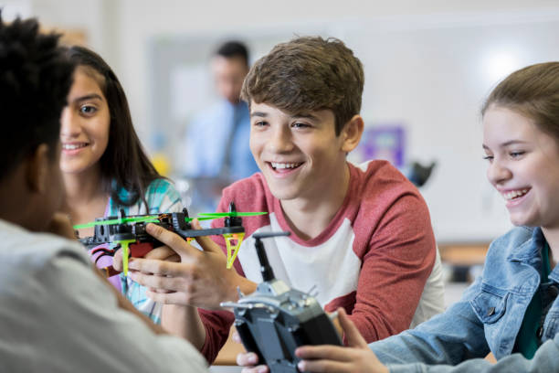 Team of high school students build drone Confident group of teenage boys and girls build a drone in their engineering class. robotics photos stock pictures, royalty-free photos & images