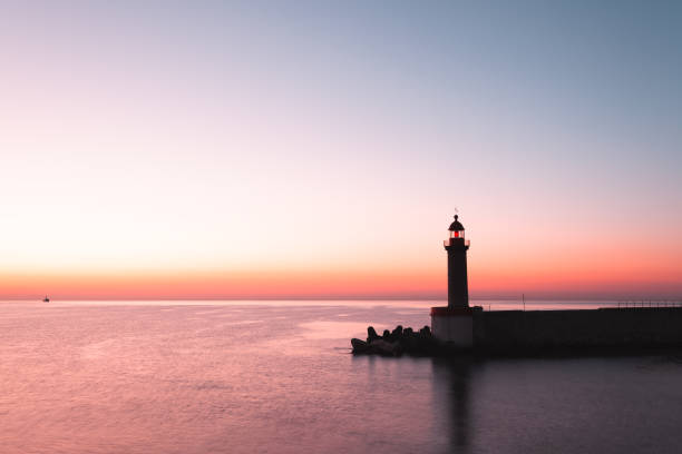 White and red lighthouse in the middle of the beach with blue sky