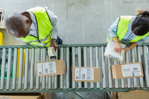 high angle view of people working in distribution warehouse - parcel label imagens e fotografias de stock