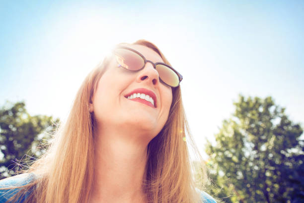 istock Smiling Woman Outdoors Wearing Sunglasses 962643914