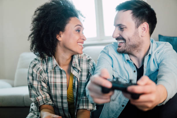 istock Young couple playing video games and looking at each other 962643938