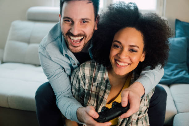 istock Young couple playing video games and hugging 962644044