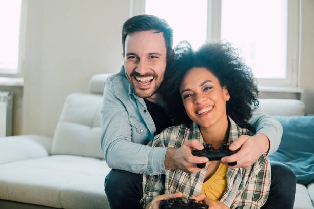 istock Joyful couple hugging and playing video games 962644160