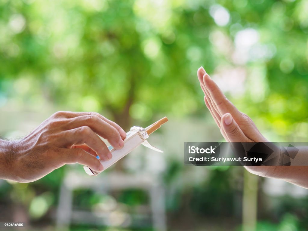Kein Rauchen. Nahaufnahme von männlichen Händen halten Zigaretten und Person vorschlagen. Der menschliche Arm ist mit Ablehnung auf Bokeh Hintergrund Gestikulieren. - Lizenzfrei Rauchen einstellen Stock-Foto