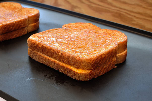 Two grilled cheese sandwiches on a hot plate stock photo