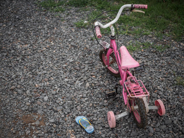 istock Children's bicycle and shoe on stone road. missing children concept. international missing children's day. 962648630