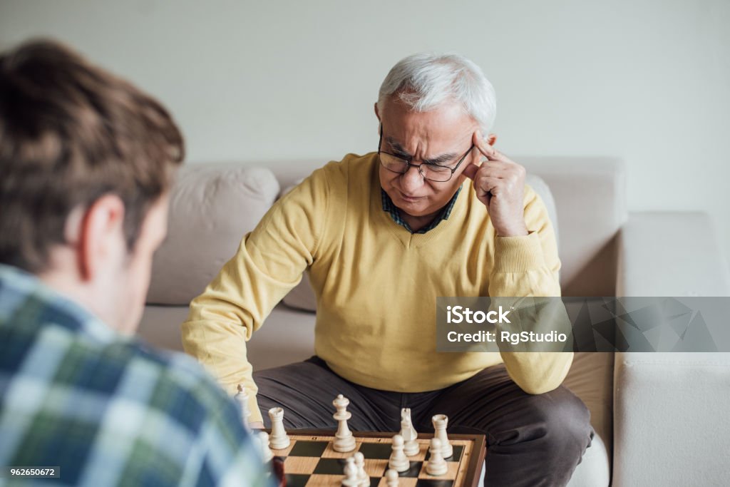 Elderly Man Contemplating Next Chess Move Stock Photo - Download Image Now  - Active Lifestyle, Active Seniors, Adult - iStock