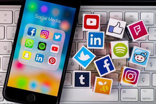 İstanbul, Turkey - May 24, 2018: Plastic cubes with popular social media services icons, including Facebook, Instagram, Youtube, Twitter and an Apple iPhone 8 smart phone on an Apple iMac computer keyboard.