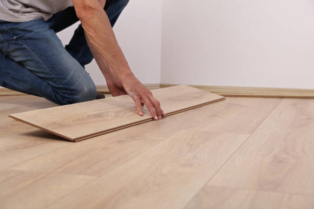 istock Man installing new laminated wooden floor close up 962655256