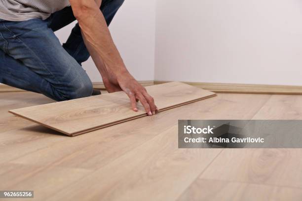 Man Installing New Laminated Wooden Floor Close Up Stock Photo - Download Image Now - Adult, Apartment, Blue-collar Worker