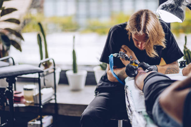 istock Artist making tattoo on leg in studio 962658668