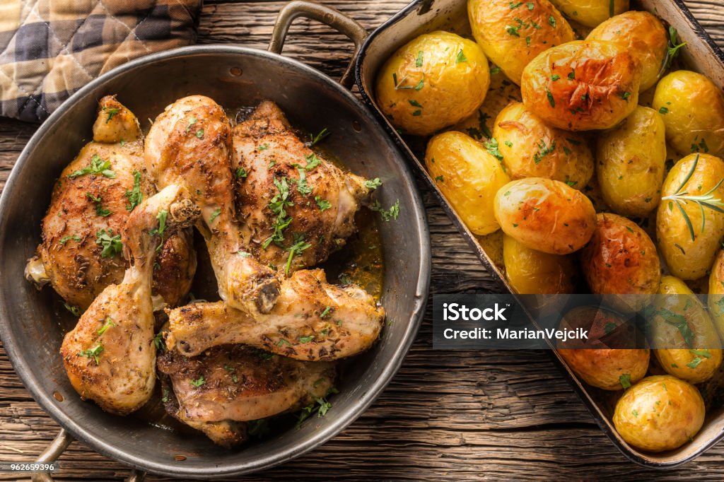 Roasted chicken legs with potatoes cumin pepper and herbs top of view Roasted chicken legs with potatoes cumin pepper and herbs top of view. Chicken Meat Stock Photo