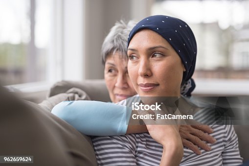 istock An Asian woman in her 60s embraces her mid-30s daughter who is battling cancer 962659624