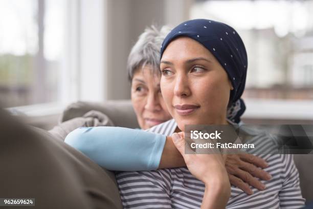 An Asian Woman In Her 60s Embraces Her Mid30s Daughter Who Is Battling Cancer Stock Photo - Download Image Now