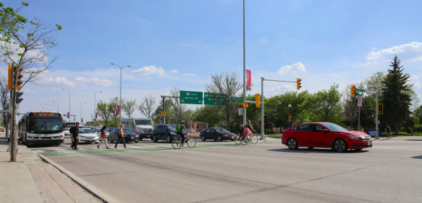 motociclisti e pedoni attraversano il marciapiede in una giornata di sole - canada main street manitoba winnipeg foto e immagini stock