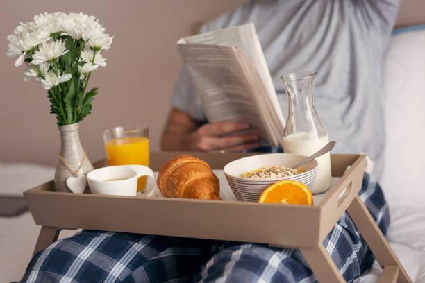 istock Man reading newspapers and having breakfast in bed 962663138