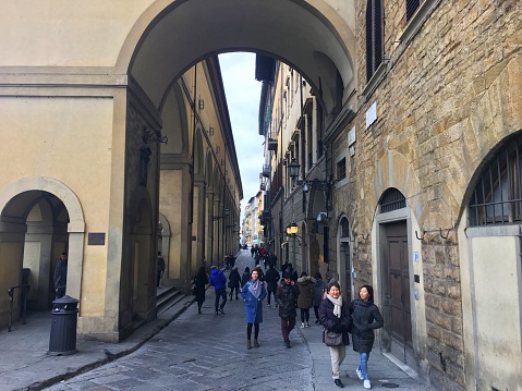 Florence, Italy - December 24, 2017: Lungarno Anna Maria Luisa de' Medici and the visitors just before the Ponte Vecchio.