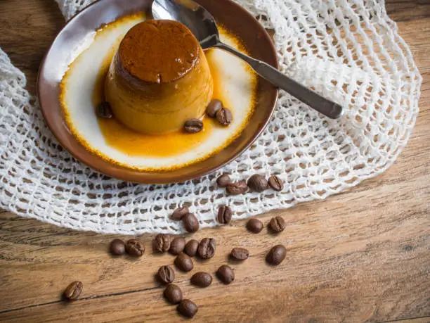 Coffee flan in a plate on wood background