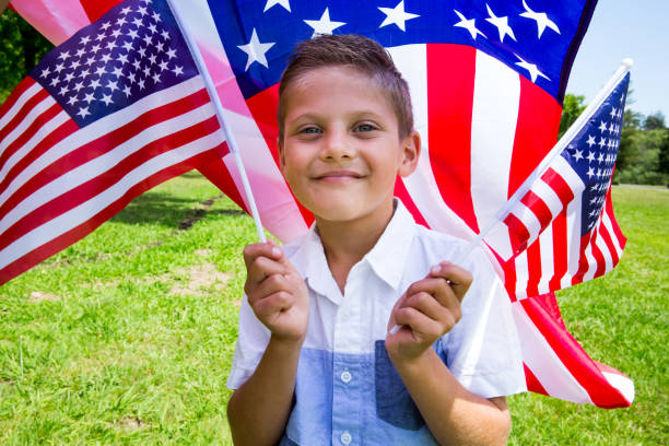 istock Little boy holding american flag outdoors on beautiful summer day 962682948