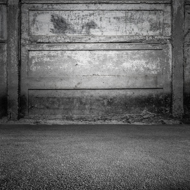 istock Grungy gray concrete wall and asphalt 962689100