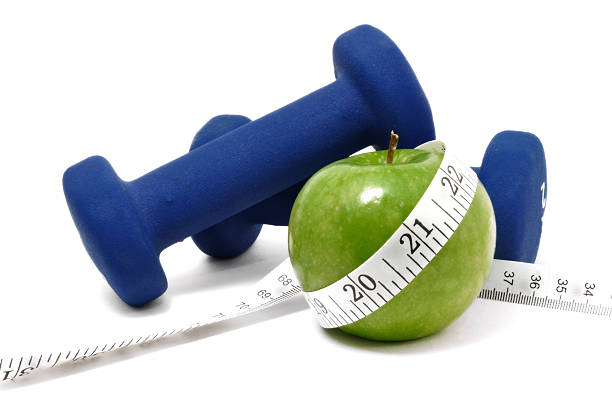 Big red apple on a kitchen scale on white background