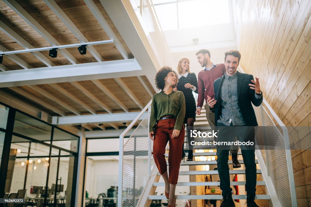 They inspire each other Group of coworkers going down the stairs and talking Staircase Stock Photo