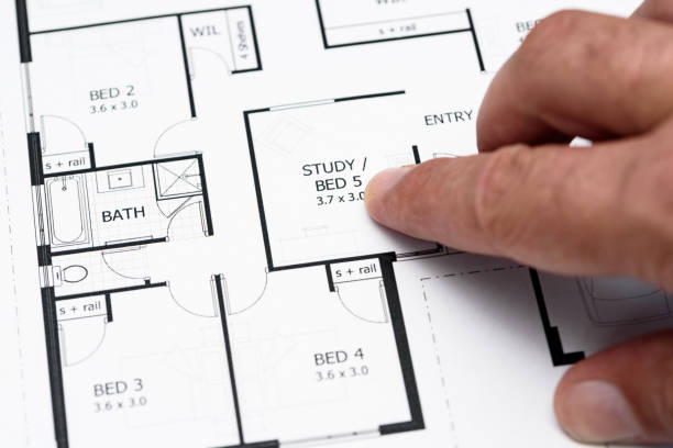 Mans finger pointing to house plans