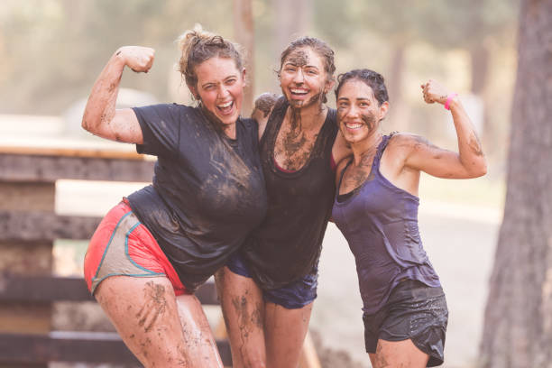 istock Portrait of three female mud run competitors 962693430