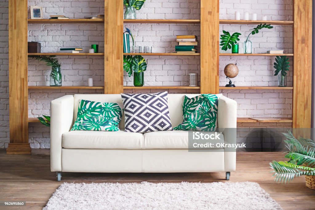 Cozy light room with plants, white sofa and stylish furniture in scandinavian style. Living room interior concept. Selective focus. Space for text. Cozy light room with plants, white sofa and stylish furniture in scandinavian style. Living room interior concept. Selective focus. Space for text Apartment Stock Photo