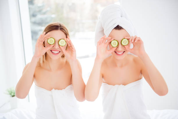 istock Pretty, charming, cheerful, attractive, comic, playful, stylish models wrapped in towels holding round pieces on eyes place, having soft, smooth skin, wellness, wellbeing, enhancement concept 962696436