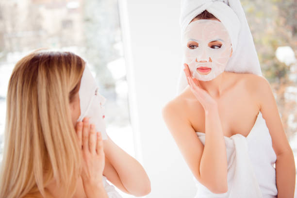 istock Charming, pretty, sexy, stylish models after bath wrapped in towels applying, using face mask for soft, smooth, silk, sensual, dry, oiled face skin, wellness, wellbeing, perfection concept 962700626