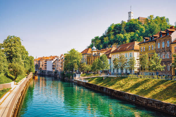 Waterfront of Ljubljanica River and Old castle Ljubljana Slovenia Waterfront of Ljubljanica River and Old castle on Castle hill in the historical center of Ljubljana, Slovenia embankment photos stock pictures, royalty-free photos & images