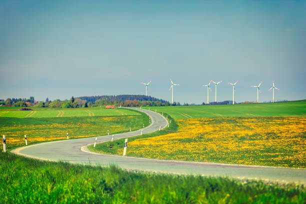 Wind turbines on hill covered by meadow and forest during springtime day with blue sky - Straz hill near As town in Czech republic near borders with Germany