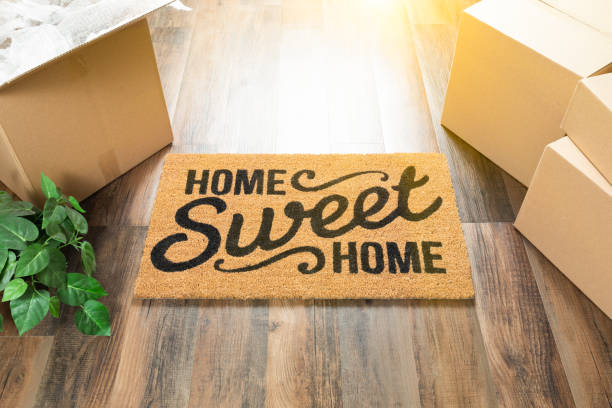 home sweet home willkommene matte, bewegliche boxen und anlage auf harte hölzernen fußböden - door mat stock-fotos und bilder
