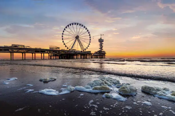 Landscape of a sunset at the beach and the pier of Scheveningen with nobody, no tourists, The Hague, Netherlands