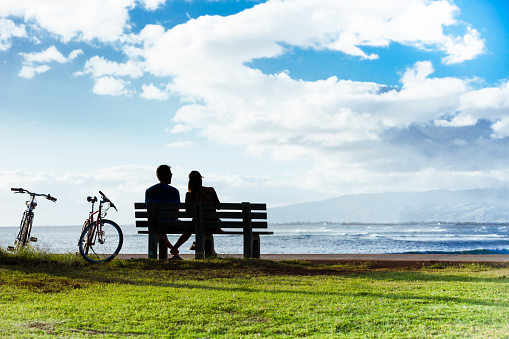 Man and woman relaxing on a park bench enjoying the beautiful view.