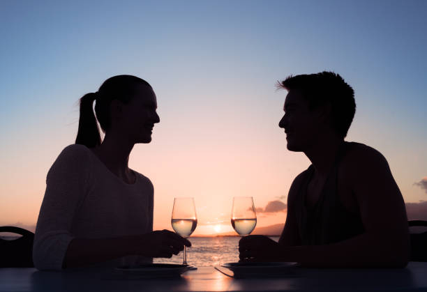 istock Couple enjoying glass of wine with beautiful sunset setting 962714042