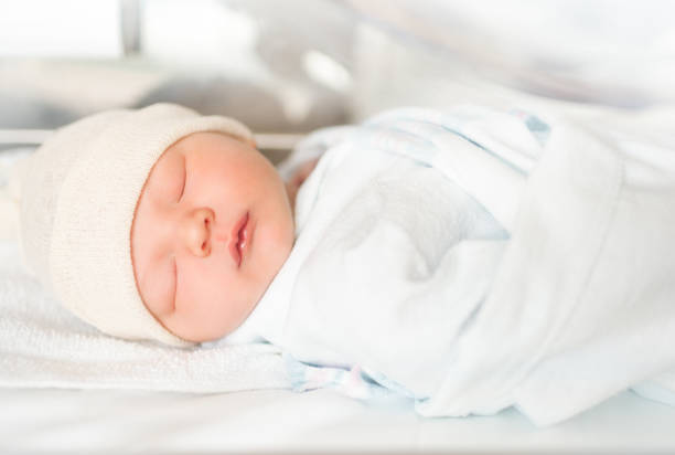 Portrait of beautiful baby sleeping. Newborn baby boy sleeping in the hospital nursery. hospital baby blankets stock pictures, royalty-free photos & images