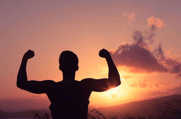 istock Silhouette of strong man flexing outdoors. 962714168