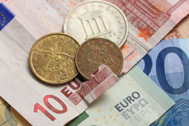 istock torn euro note and vintage greek coins 962720762