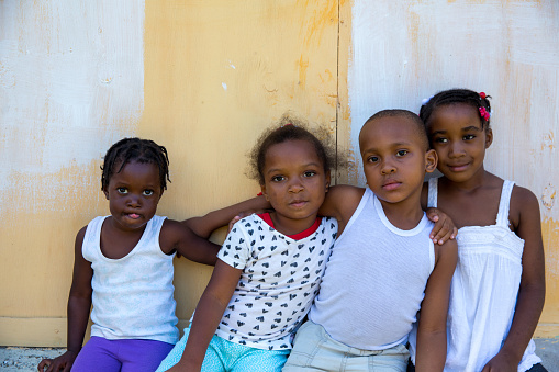 Portrait of three young girls and a boy outside in a poor village in Jamaica. Shot with Canon 5D Mark lll.