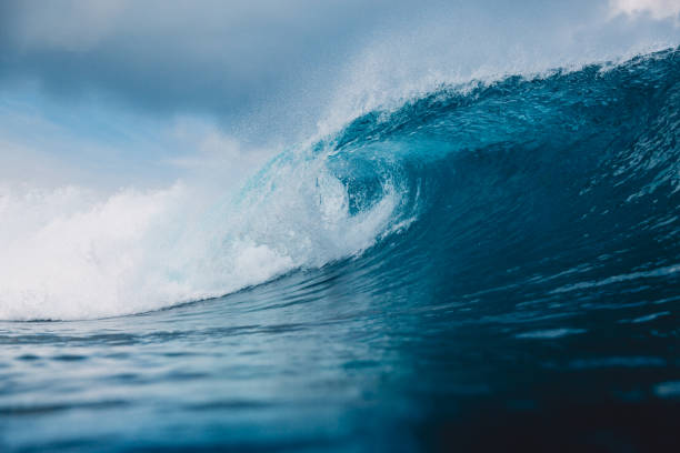 istock Breaking barrel wave in ocean. Blue wave and sky with clouds in Bali 962730556