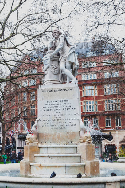 a fonte de shakespeare e a estátua de mármore de william shakespeare, rodeado por golfinhos, esculpidos por giovanni fontana, localizado no pequeno parque em leicester square garden na cidade de westminster, londres, reino unido - shakespeare and company - fotografias e filmes do acervo