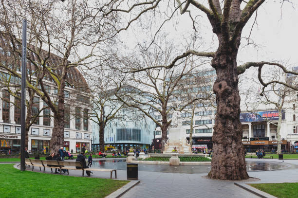 a fonte de shakespeare e a estátua de mármore de william shakespeare, rodeado por golfinhos, esculpidos por giovanni fontana, localizado no pequeno parque em leicester square garden na cidade de westminster, londres, reino unido - shakespeare and company - fotografias e filmes do acervo