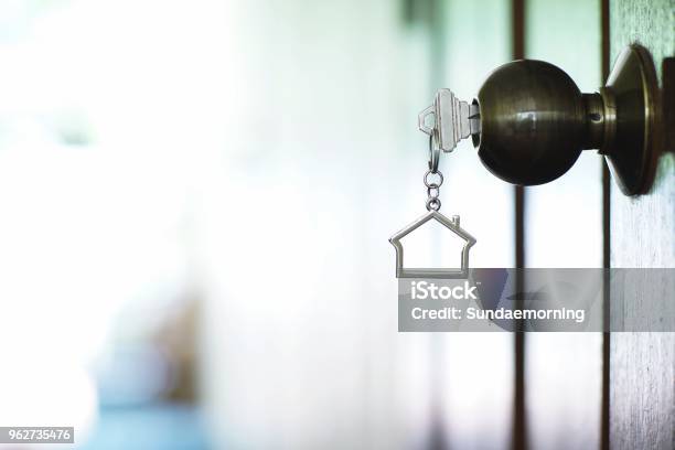 Home Key With Metal House Keychain In Keyhole Property Concept Stock Photo - Download Image Now