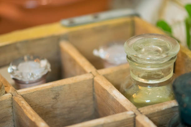 Spices in vintage bottles in wooden box.